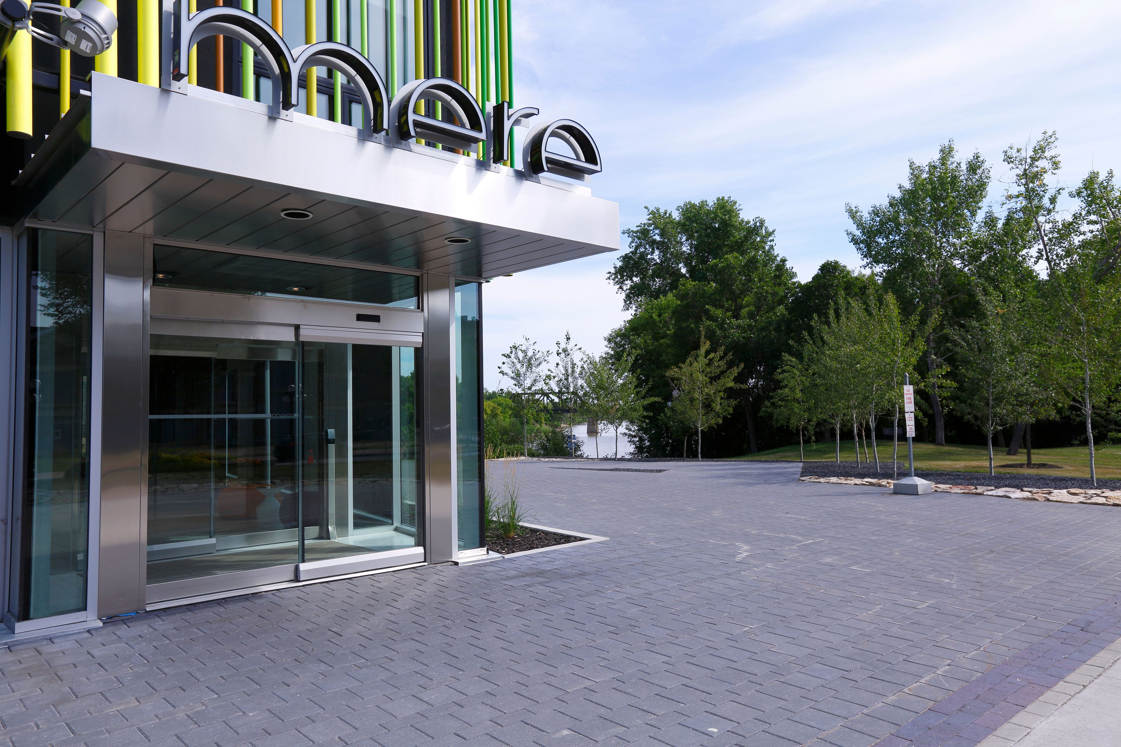 A modern building with a glass entrance and a sign above it.