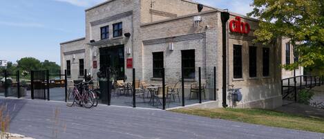 A building with a brick facade, a bicycle parked outside, and outdoor seating.