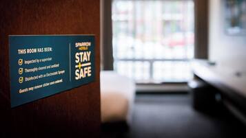A sign indicating room safety measures including inspection, cleaning, and disinfection.