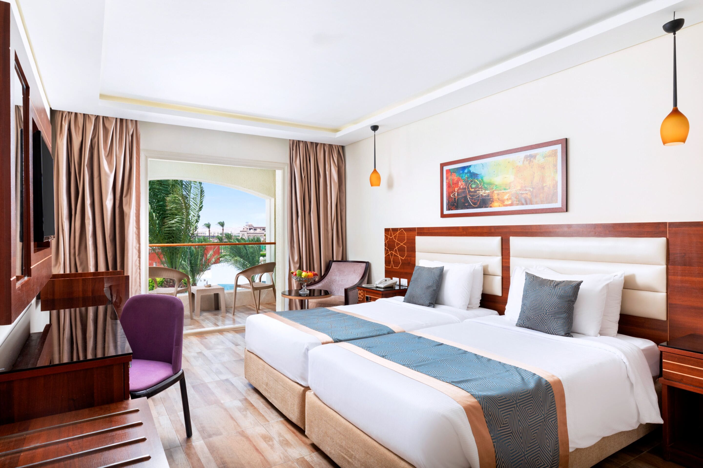 Ein Hotelzimmer mit einem großen Bett, einem Schreibtisch, einem Stuhl und einem Vorhangfenster.
