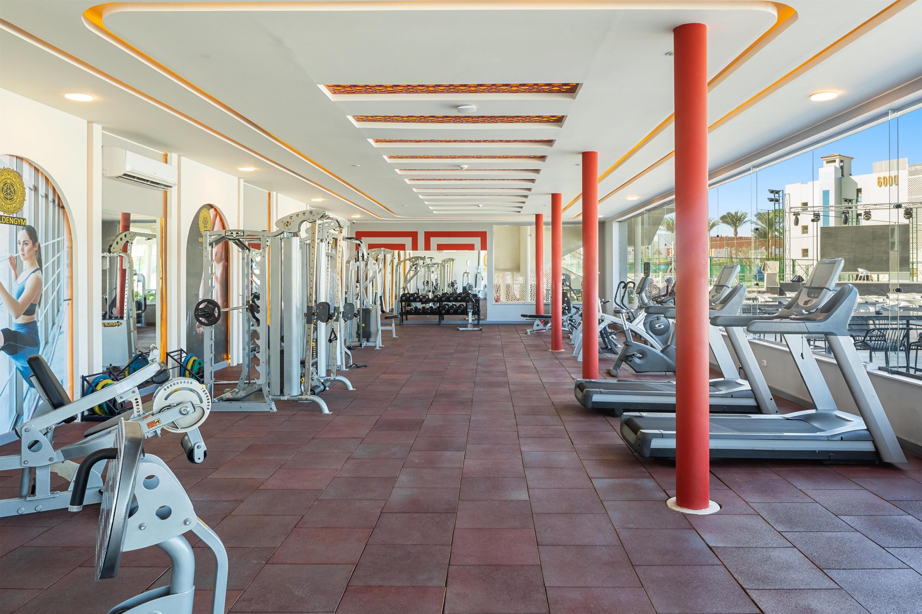 A gym with exercise equipment, treadmills, and a red pillar.