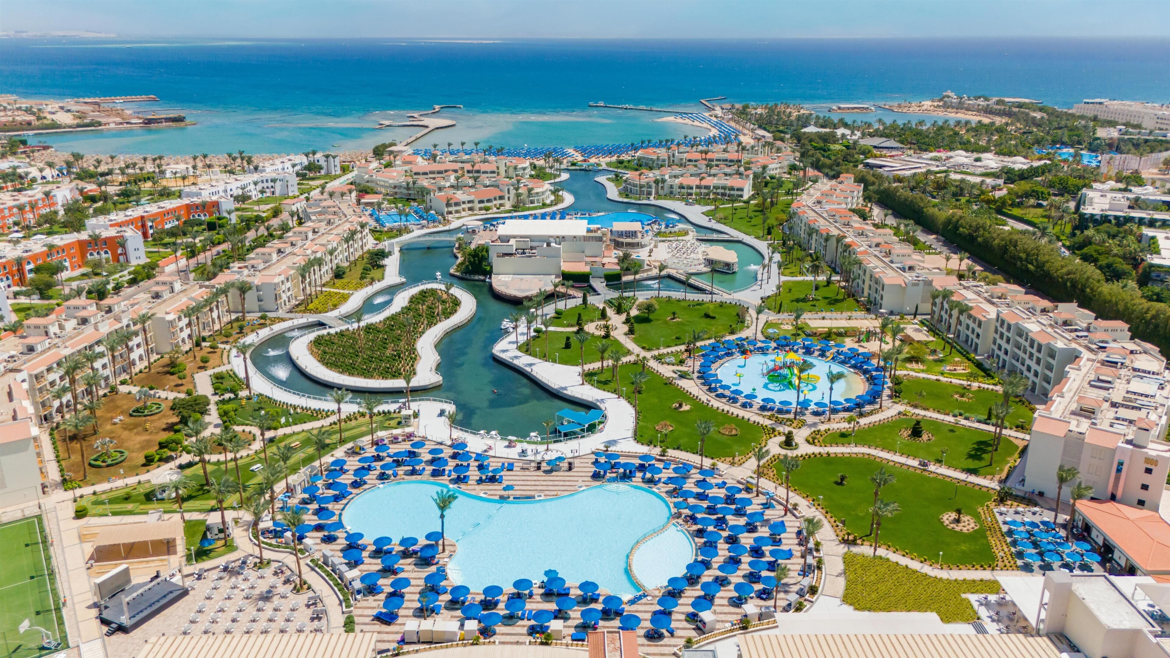 A resort with multiple swimming pools, a marina, and beachfront views.