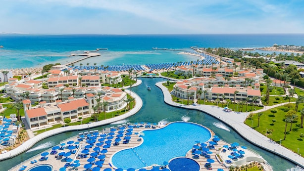 A resort with multiple swimming pools, a marina, and beach areas.