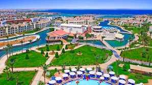 A resort with multiple swimming pools, a marina, and a beachfront.