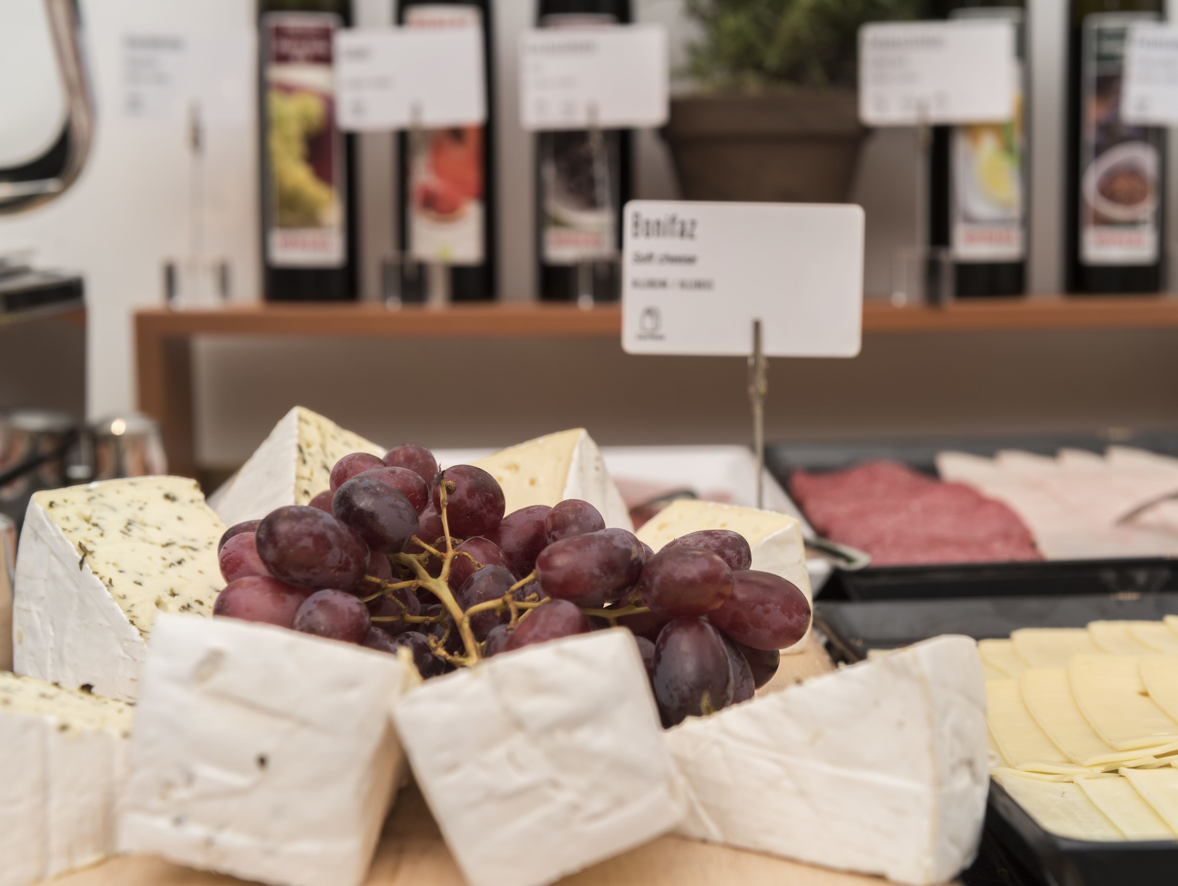 Presentación de queso y uvas con un cartel que indica 'Bordatoz'.
