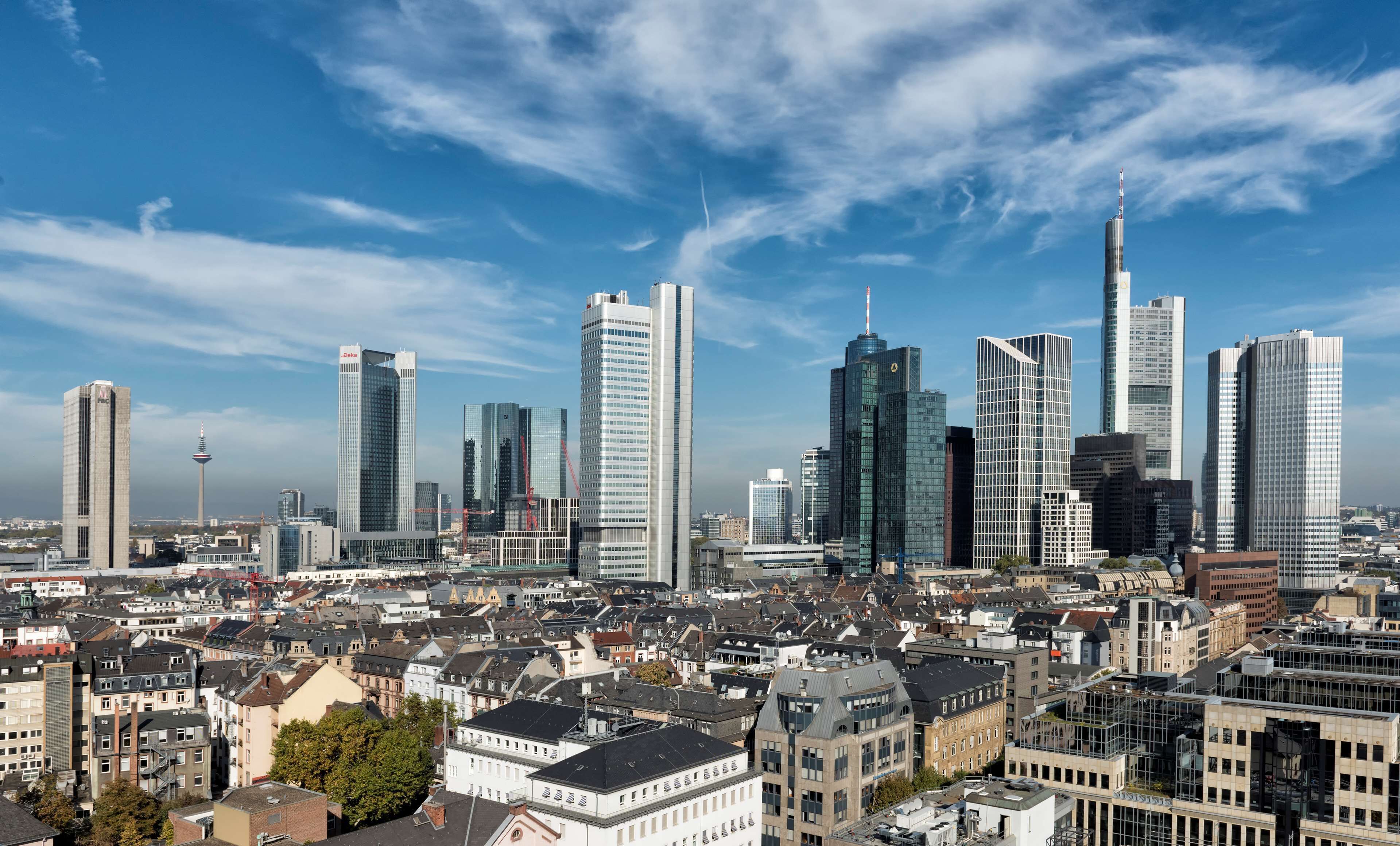 A cityscape with modern skyscrapers and a mix of older buildings.