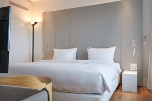 A modern hotel room with a large bed, bedside tables, a flat-screen TV, and a bedside lamp. - Scandic Frankfurt Museumsufer (Frankfurt)