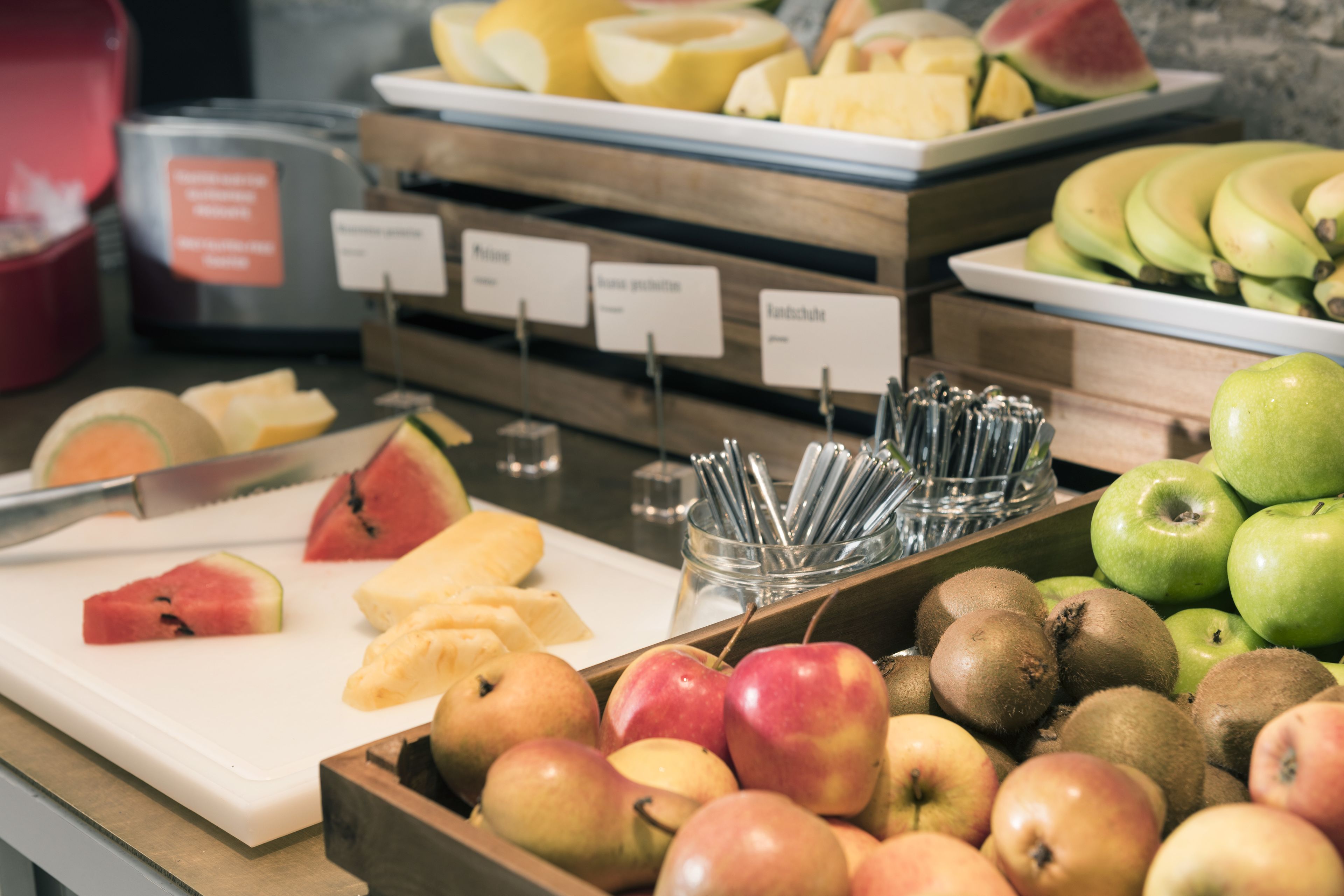 A fruit display with various types of fruits and a knife.