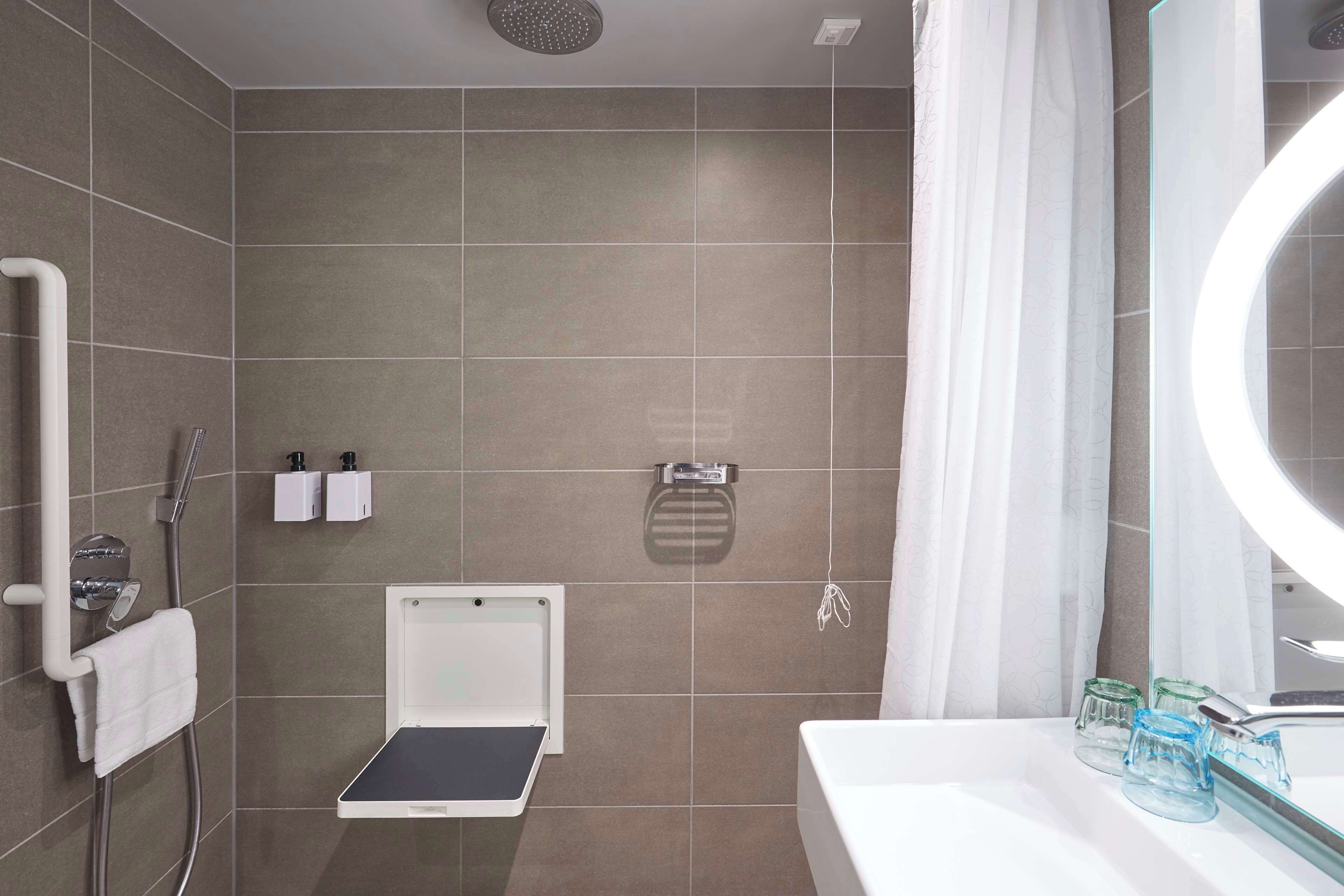 A modern bathroom with a shower, toilet, and sink.