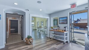 A hotel lobby with a reception desk, a coffee station, and a view of the outside. - RiverWalk Inn (Pagosa Springs)