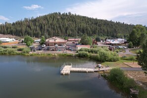 Une propriété au bord du lac, dotée d’un quai, de bâtiments et, en arrière-plan, d’une colline boisée.