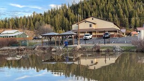 A building with a parking lot and a pond reflecting the structure. - RiverWalk Inn (Pagosa Springs)
