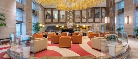 Eine geräumige Lobby mit einer zentralen Sitzecke, einem prächtigen Kronleuchter und einem modernen Design.