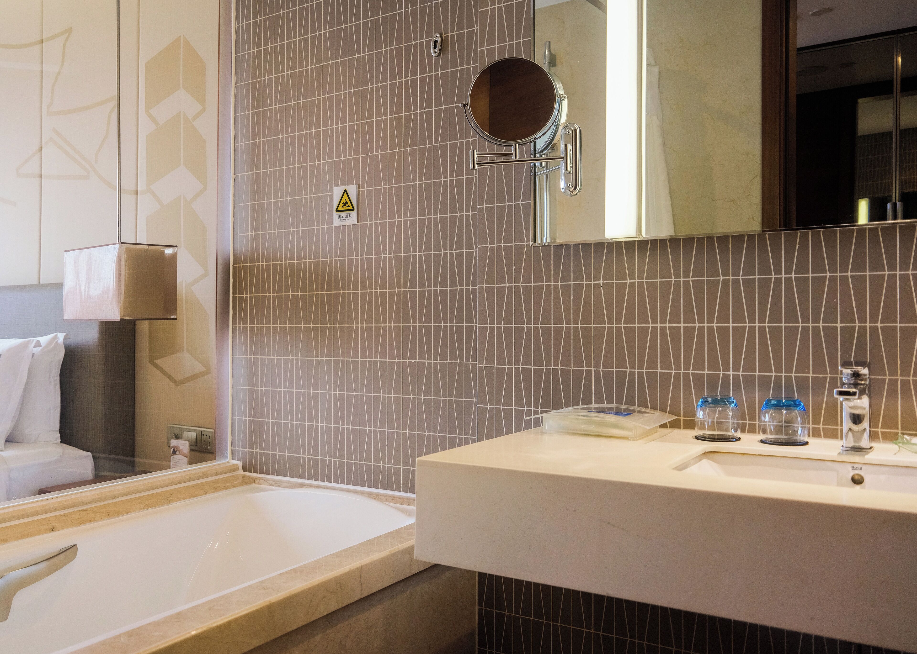 Ein Badezimmer mit einer Badewanne, einem Waschbecken mit Spiegel und einem Handtuchhalter.