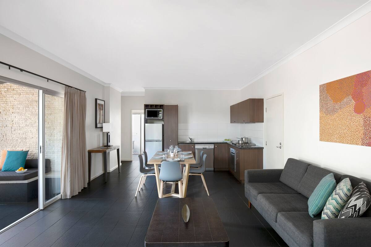 A modern apartment with a dining area, kitchen, and living space.