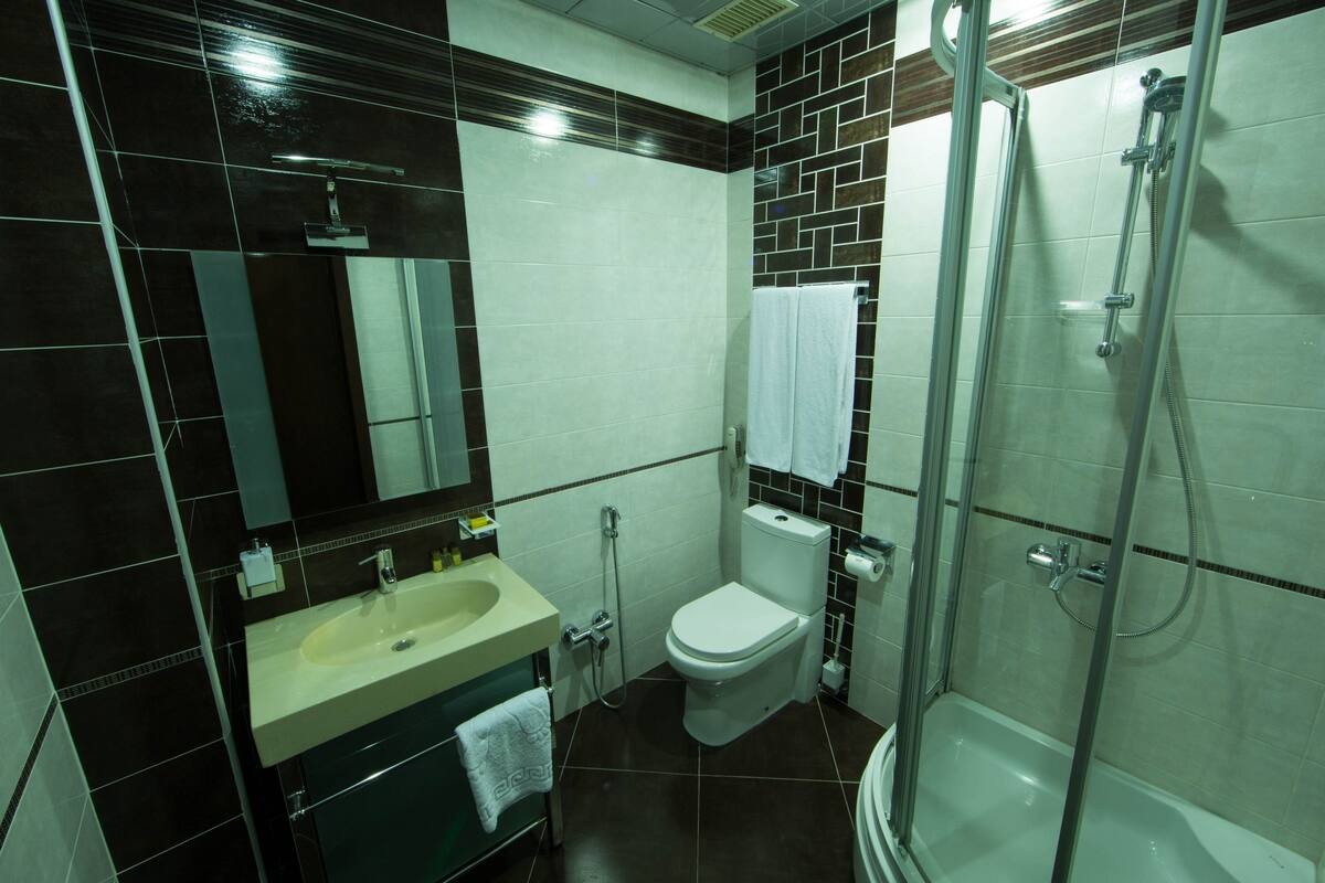 A modern bathroom with a sink, toilet, and glass-enclosed shower.