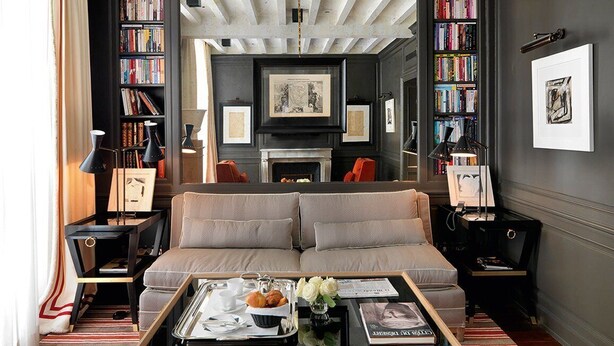 A modern living room with a sofa, coffee table, and bookshelves. - Marquis Faubourg Saint Honoré - Small Luxury hotels of the World (Paris)
