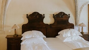 Un dormitorio con una cama de madera, dos mesitas de noche y una mesita auxiliar.