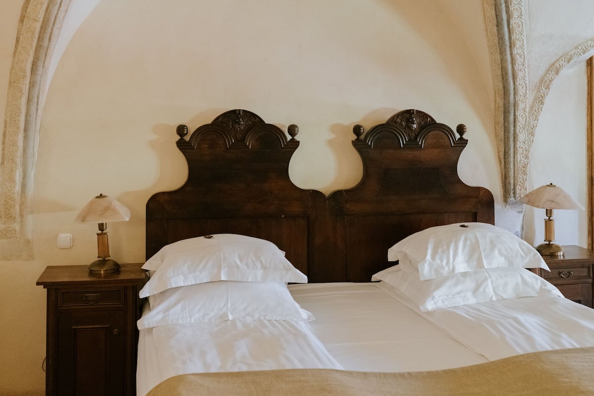 A bedroom with a wooden bed, two bedside tables, and a nightstand.