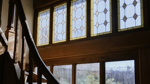 Una escalera de madera con vidrieras arriba.