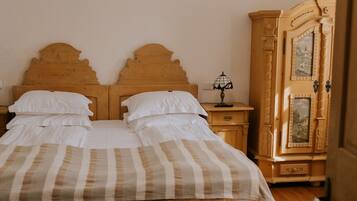 A bedroom with a wooden bed, a nightstand, a lamp, and a wardrobe.