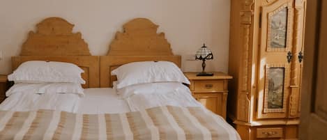 Un dormitorio con una cama de madera, una mesita de noche, una lámpara y un armario.