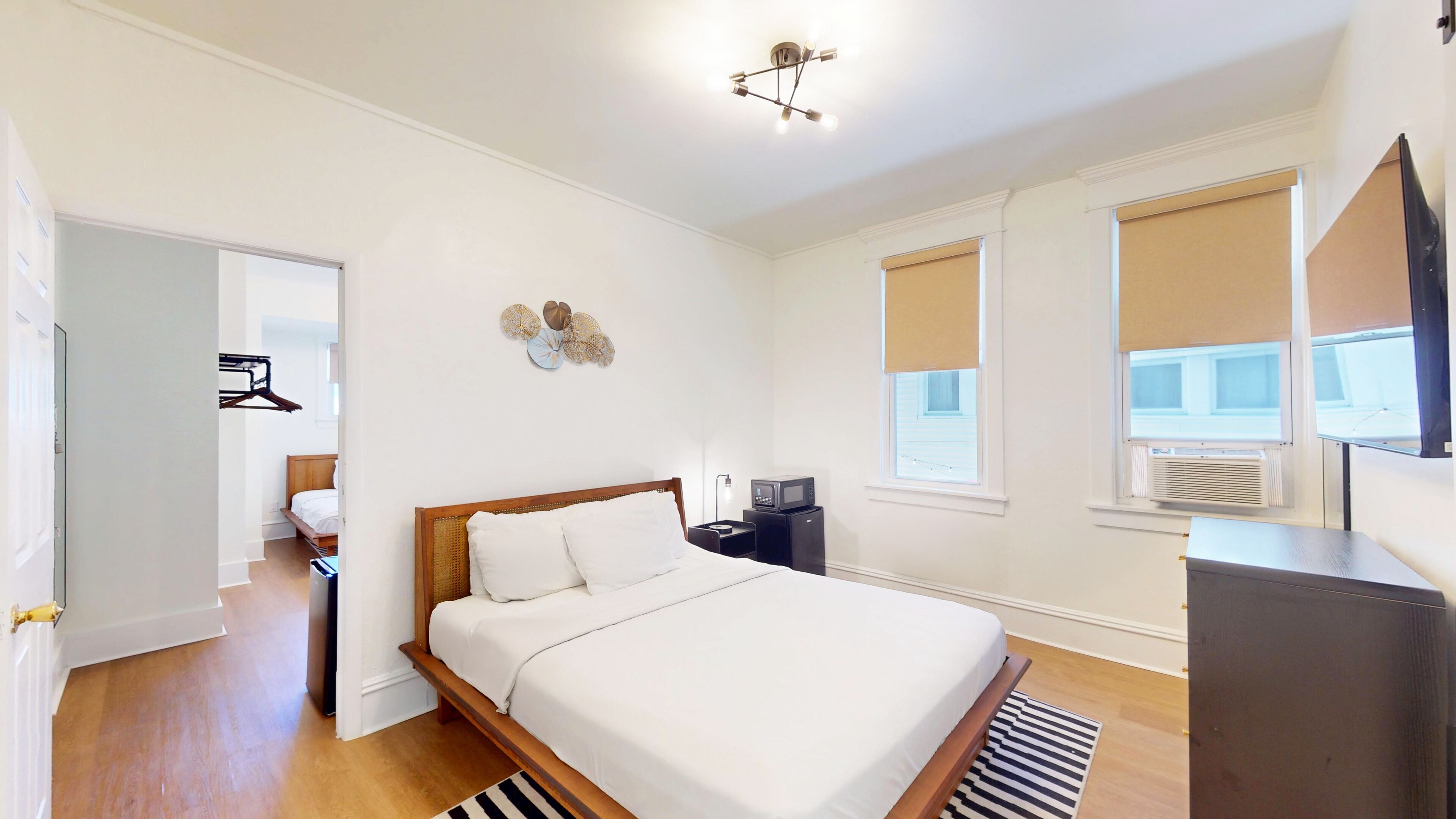 A bedroom with a bed, bedside table, lamp, and a flat-screen TV.