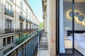 A hotel room with a balcony overlooking a narrow street with buildings. - H10 Port Vell (Barcelona)