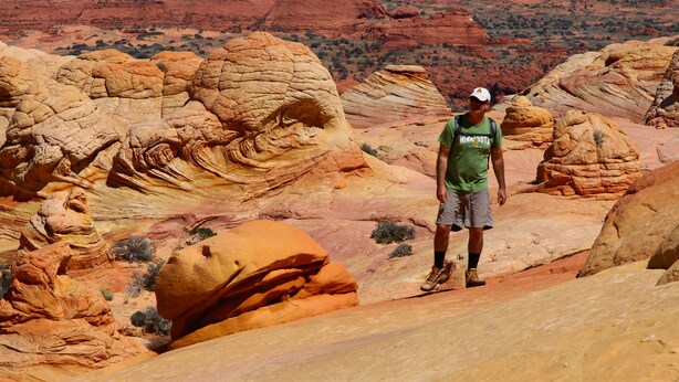 A person standing on a rock formation with a mountainous landscape in the background. - Best Western View Of Lake Powell Hotel (Page)