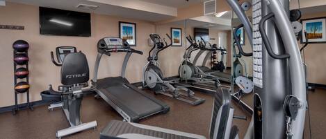 A gym with treadmills, ellipticals, and free weights.