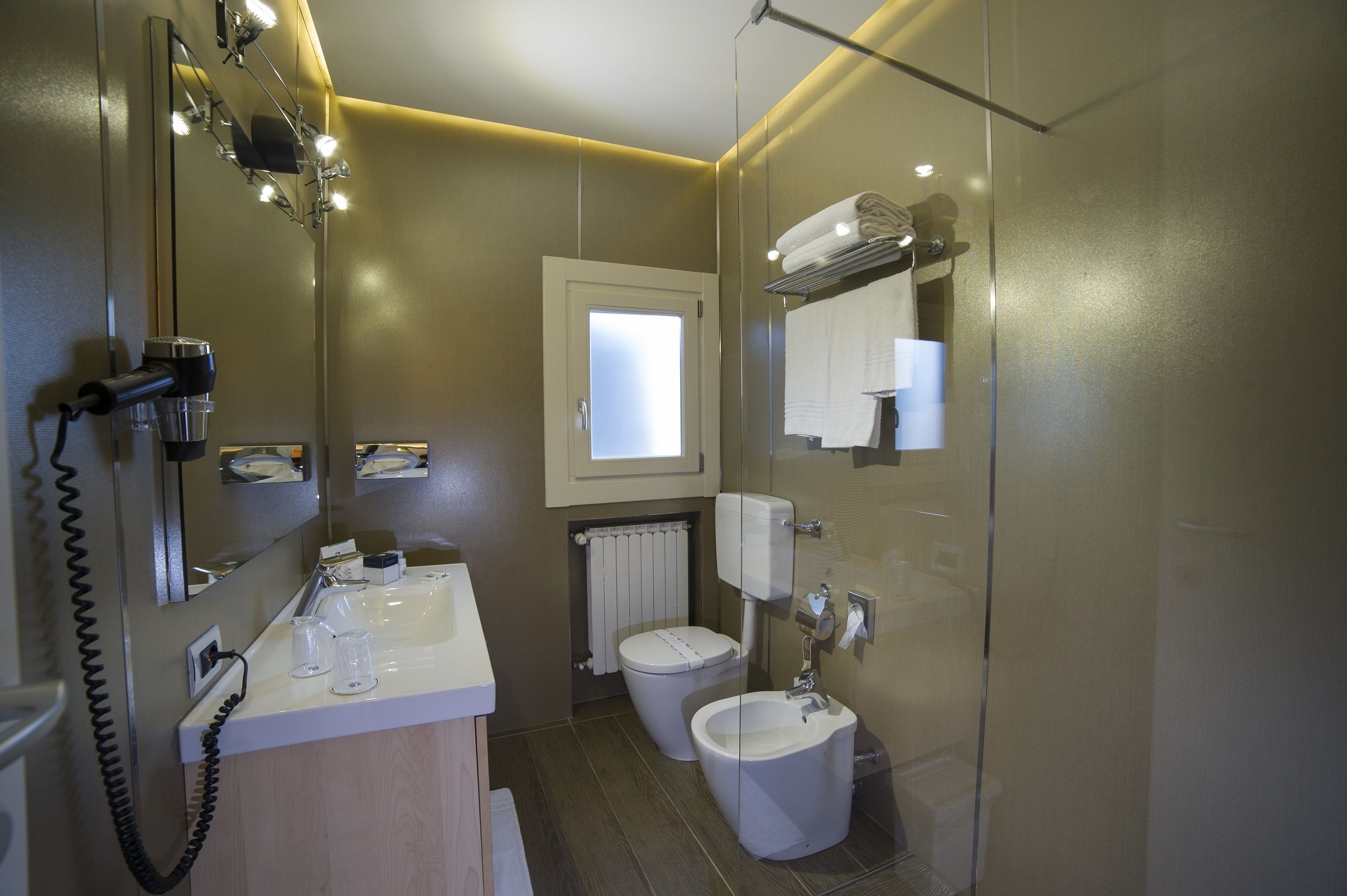 A modern bathroom with a sink, mirror, and toilet.