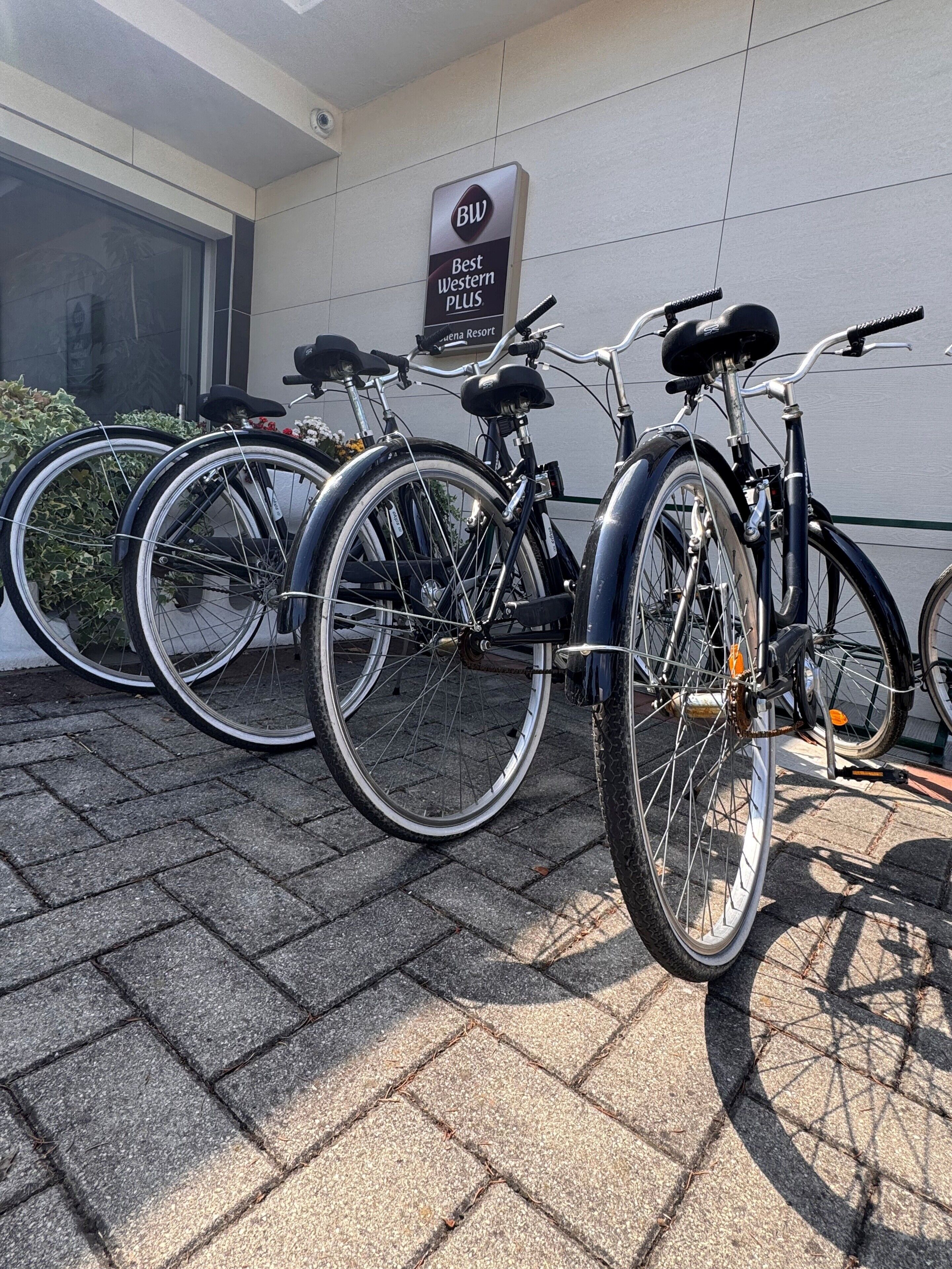 Bicycles parked outside a building with a sign that reads 'Best Western PLUS.'