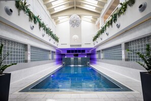 A large indoor swimming pool with a high ceiling, surrounded by walls with built-in planters and a no swimming sign. - Best Western Plus Hotel Modena Resort (Formigine)