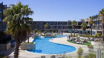 Alberca techada, alberca al aire libre y sombrillas en la alberca