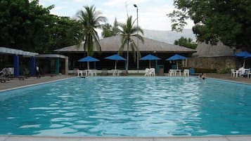 Una piscina al aire libre, sombrillas, tumbonas