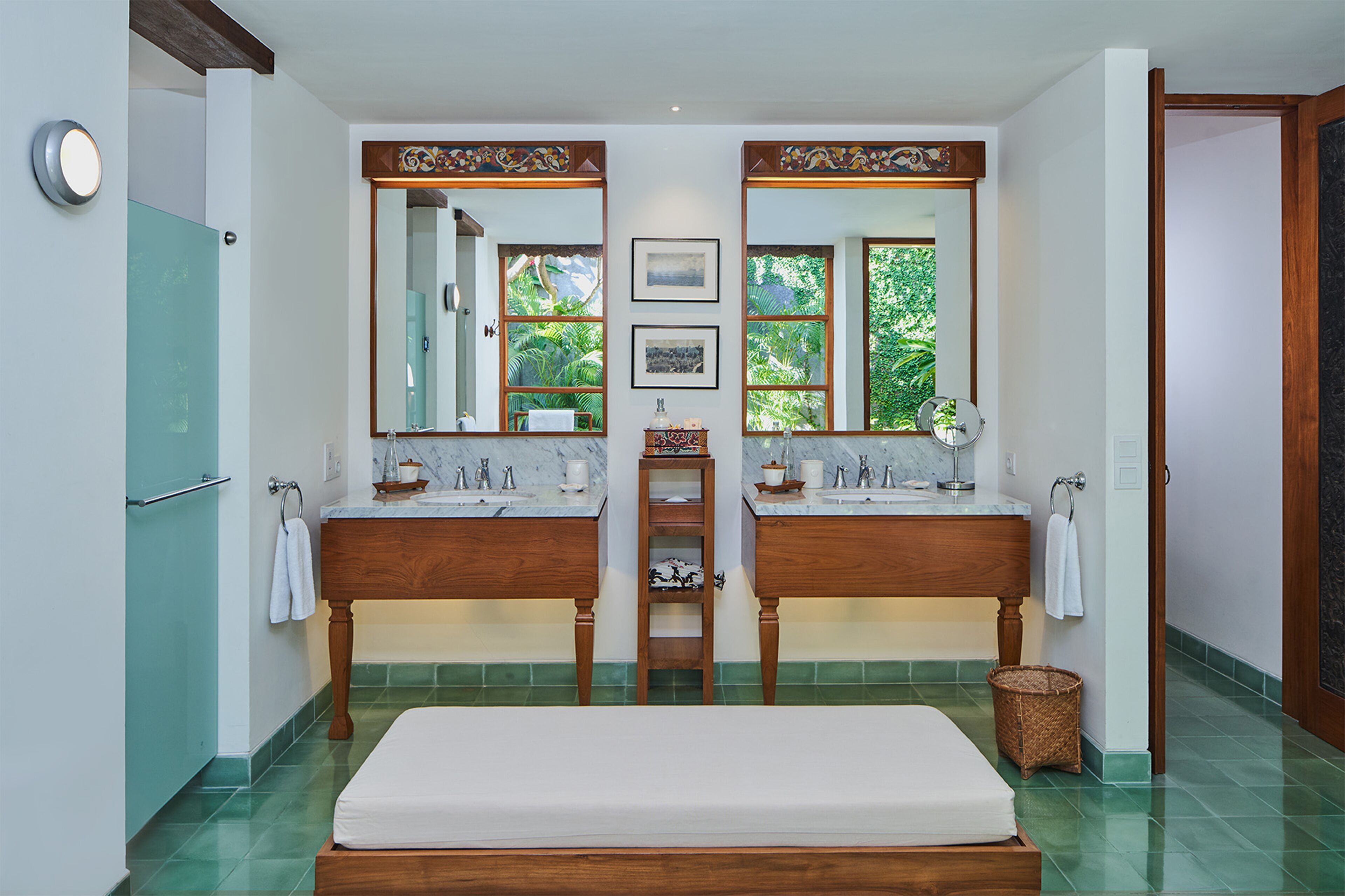 A bathroom with two sinks, a large mirror, and a wooden bench.