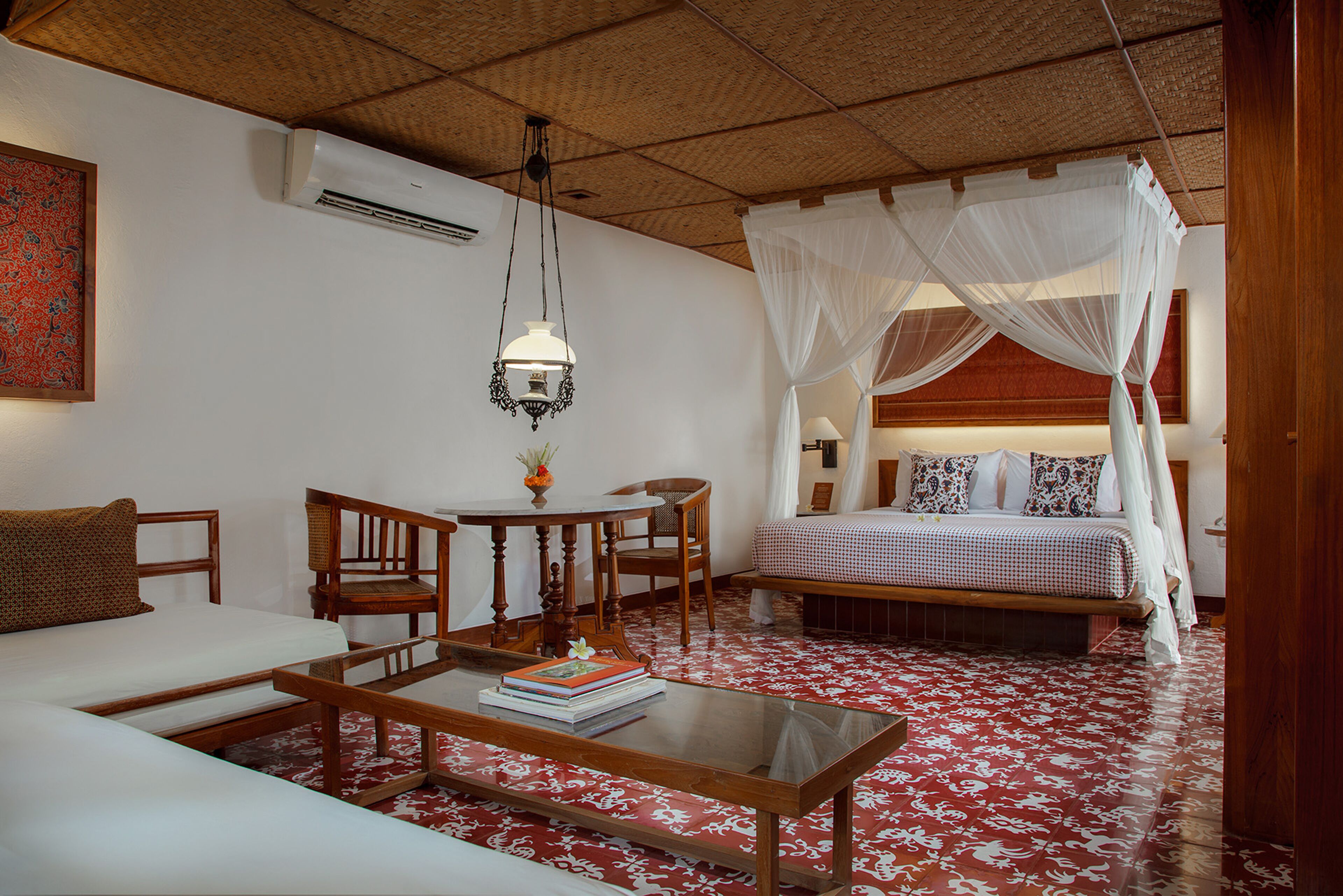 A bedroom with a bed, a sofa, a table, and a chair.