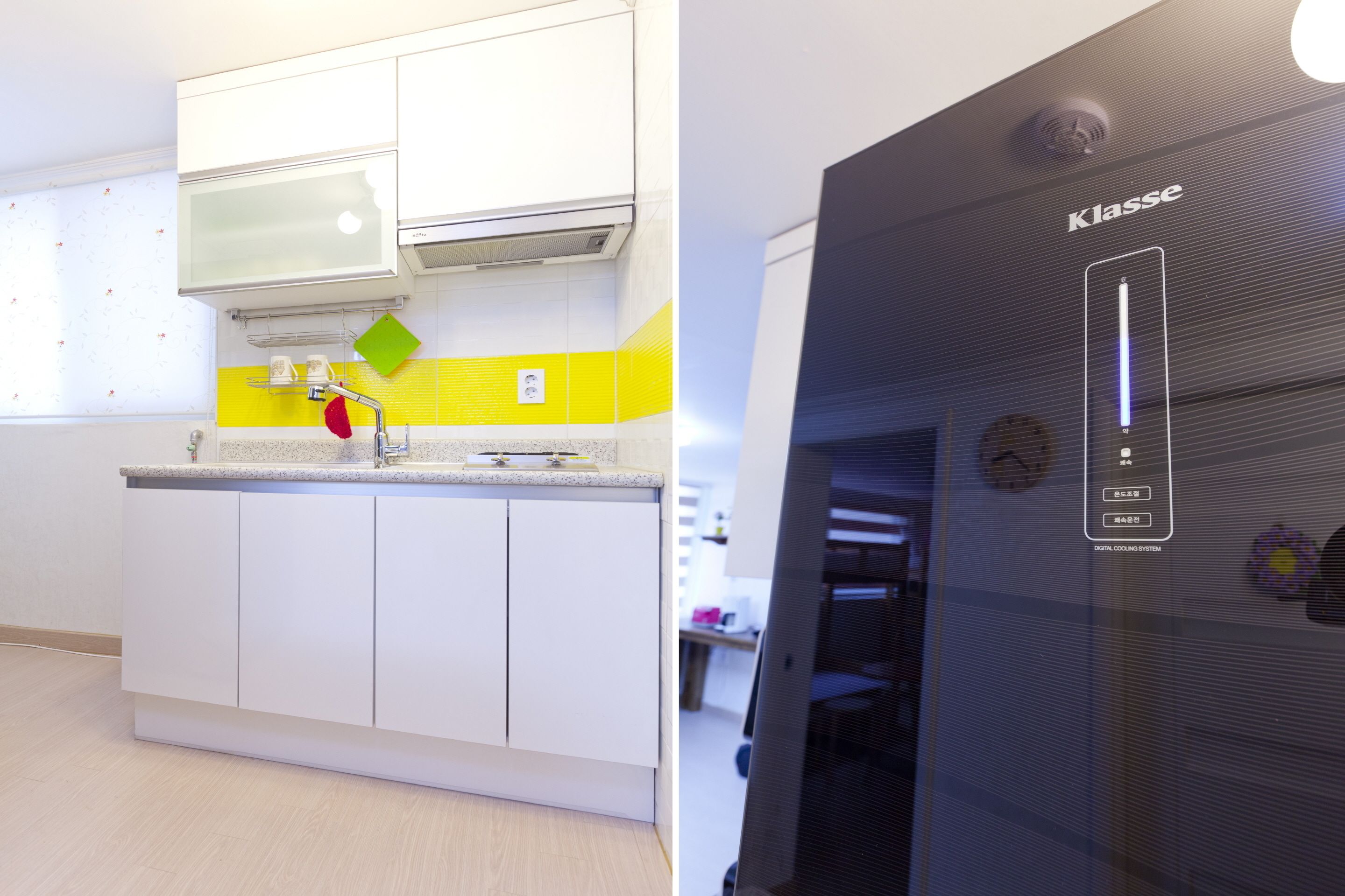 A modern kitchen with white cabinets, a yellow backsplash, and a black appliance with a digital interface.
