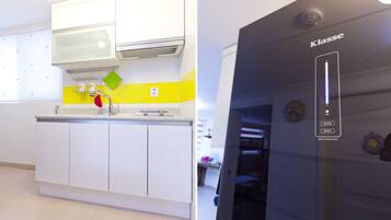 A modern kitchen with white cabinets, a yellow backsplash, and a black appliance with a digital interface.