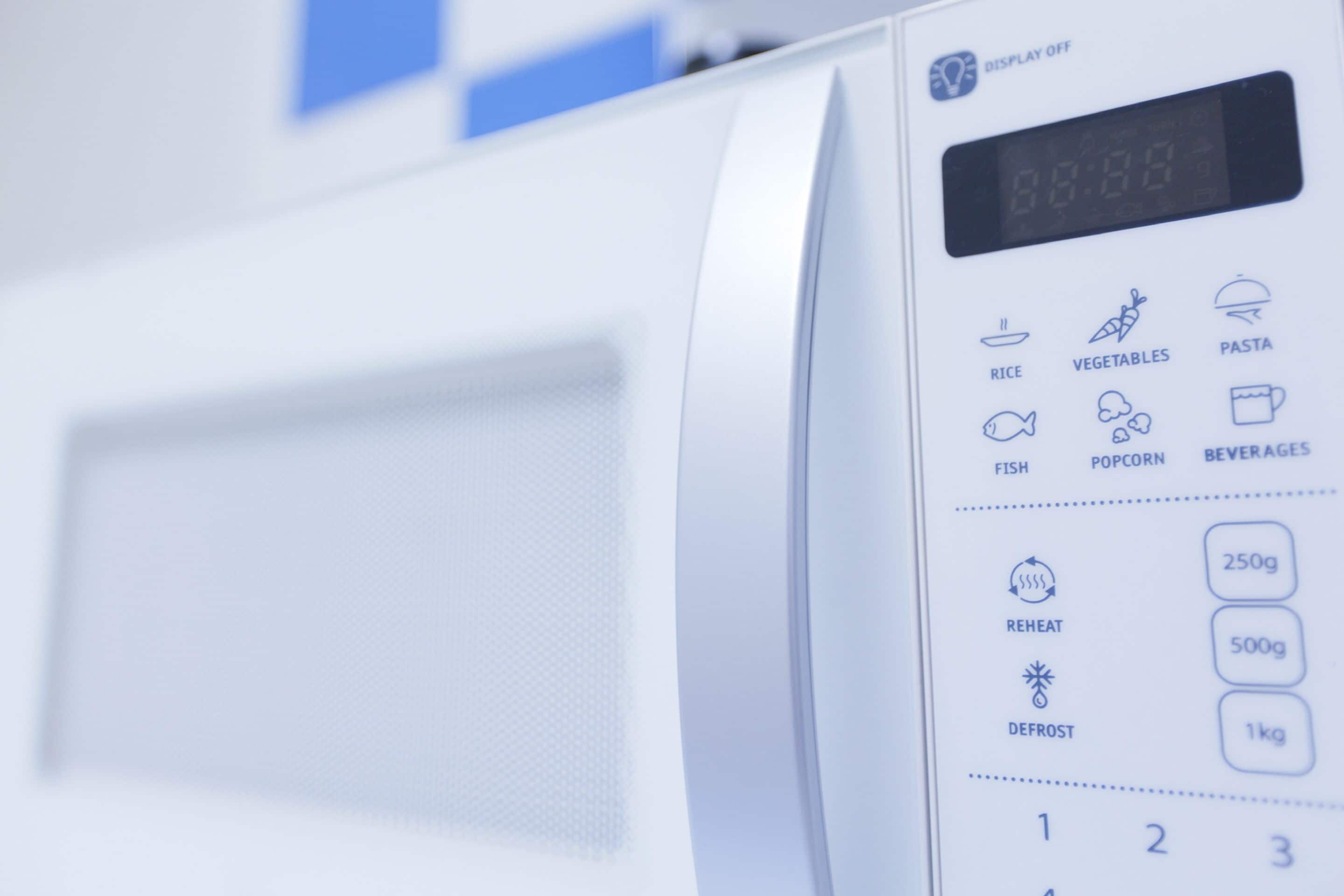 A microwave with a digital display, control buttons, and icons for rice, vegetables, pasta, fish, popcorn, and beverages.