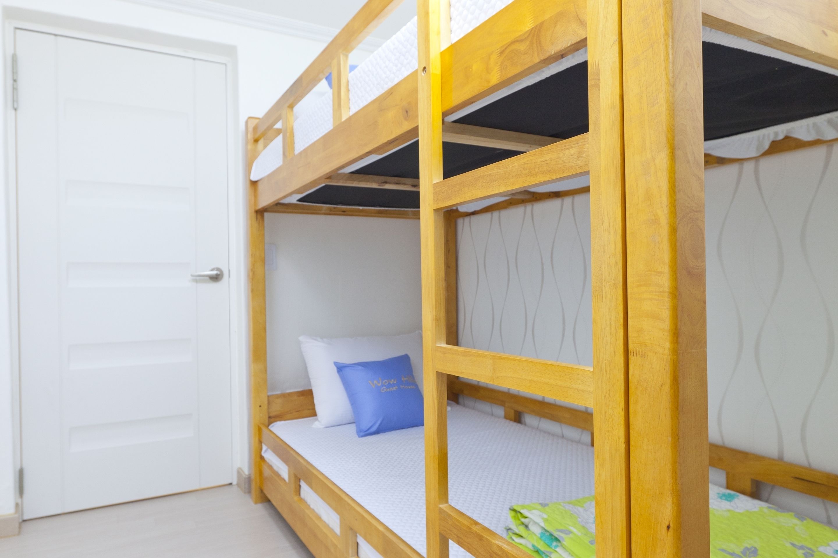 A bunk bed with a white door and a blue pillow.