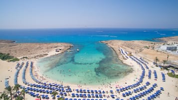 Plage, sable blanc, chaises longues, parasols