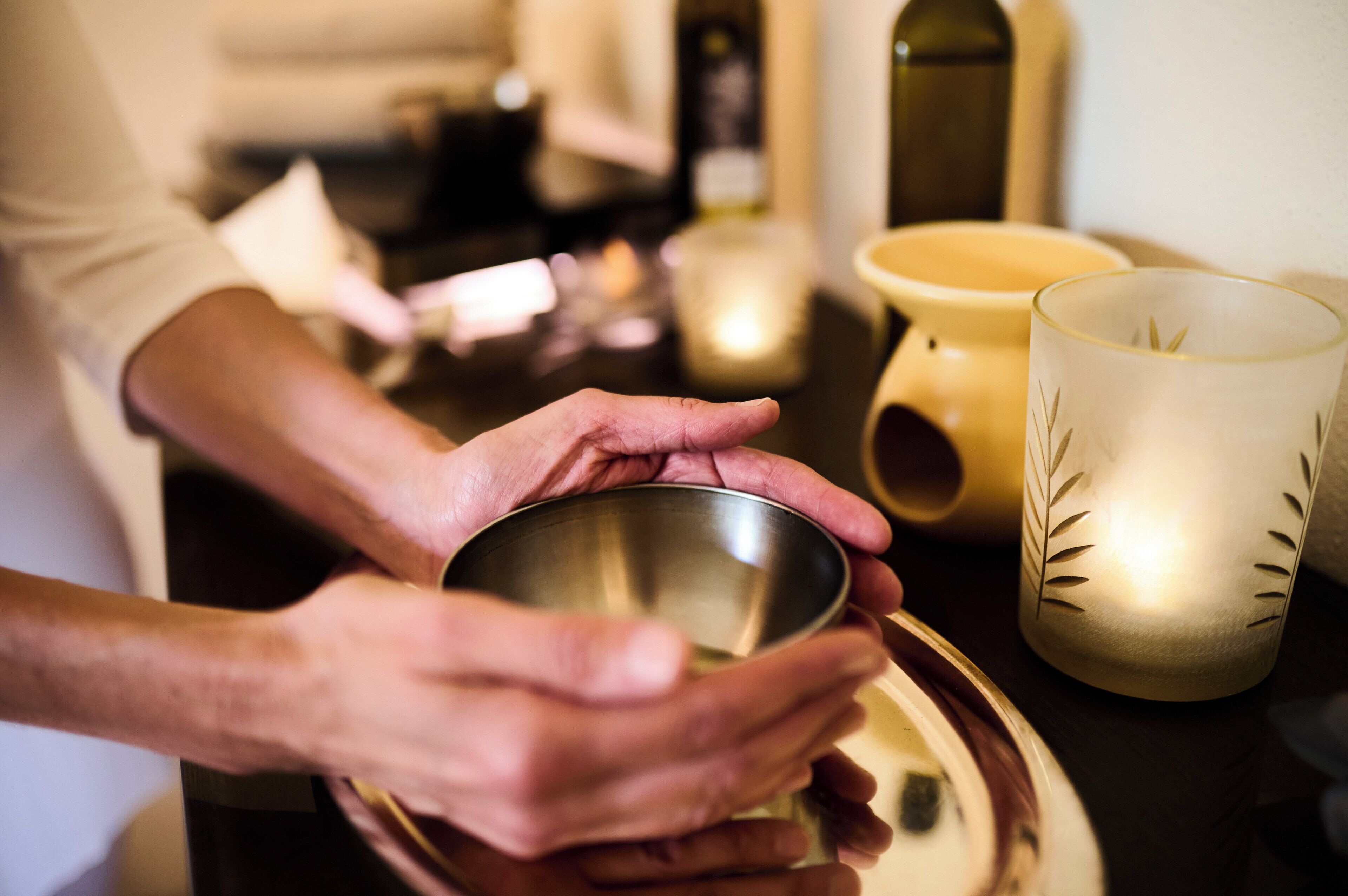 A person holding a metal bowl on a tray.