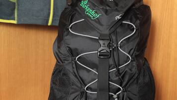 Una mochila negra con la marca 'deuter' y la palabra 'BIRKENSTOCK' a la vista.