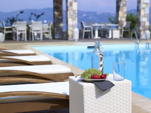 Una piscina al aire libre, sillones reclinables de piscina