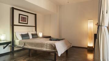 A bedroom with a bed, bedside tables, a ceiling fan, a wall-mounted artwork, and a floor lamp.