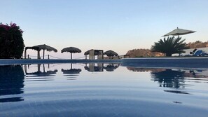 Una piscina con agua cristalina que refleja las estructuras circundantes.