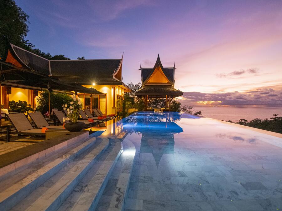 Een buitenzwembad, parasols bij het zwembad en ligstoelen