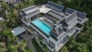 Een modern resort met een groot zwembad, diverse gastenkamers en een weelderige omgeving.
