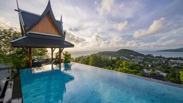 Una piscina al aire libre, sombrillas, sillones reclinables de piscina